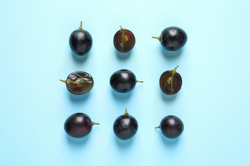 Flat lay composition with fresh ripe juicy grapes on light blue background