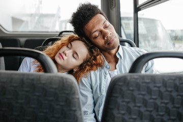 Young couple leaning their heads fell asleep on the bus