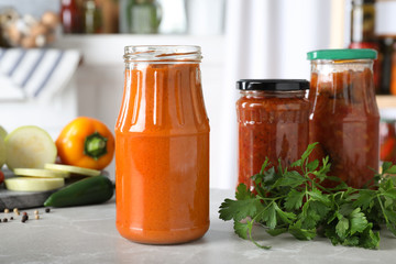 Jar with pickled squash spread on grey marble table indoors