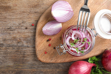 Flat lay composition with jar of pickled onions on wooden table