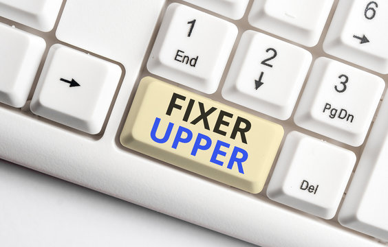 Text sign showing Fixer Upper. Business photo showcasing house in need of repairs used chiefly connection with purchase White pc keyboard with empty note paper above white background key copy space