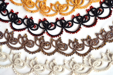 Wicker bracelletes or necklace yellow, gold, black, red, brown, white colours. Lacy weave. Tatting. Handmade jewelry made of mercerized cotton or silk with beads.