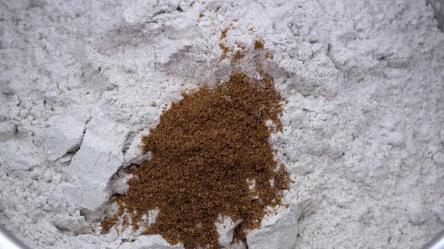 Preparation of homemade bread - adding ground cumin to the top of rye flour