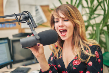 young female dj working in a modern broadcasting studio