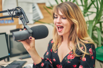 young woman dj works in a broadcasting studio