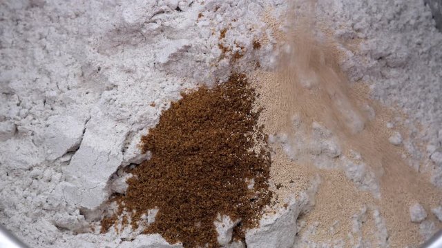 Preparation of homemade bread - adding dried yeast to flour with ground cumin