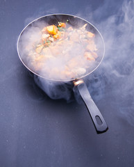 Fried meat in a frying pan closeup. Top view with copy space