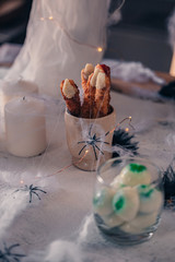 Spooky Halloween decoration with different pumpkins, light, spiders. Halloween table decoration.