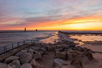 sunset on beach with rocks and lighthouses