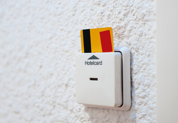 Side close-up view of yellow security hotelcard in the reader in the modern hotel room