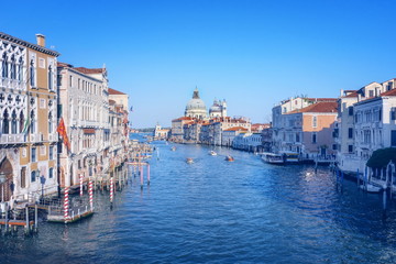 Fototapeta na wymiar Beautiful Venetian view with boats on Grand Canal and Basilica Santa Maria della Salute, in Venice, Italy, in pastel colors.