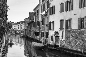 Naklejka premium Narrow canal in Venice, Italy, with boats and historic houses, in a beautiful sunny day.