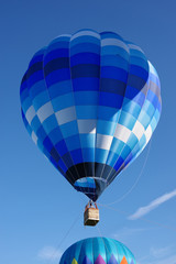 Naklejka premium Two hot air balloons flying up into the sky on a bright summer morning