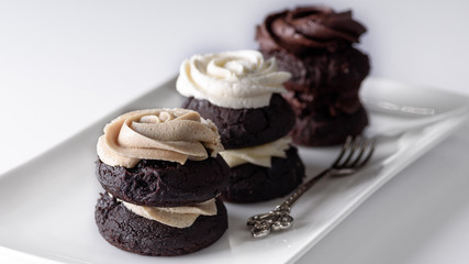 Chocolate cupcakes with various flavours of whipped cream