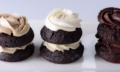 Chocolate cupcakes with various flavours of whipped cream