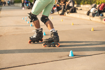 Close-up view of the rollers of a caucasian man, doing rollerblading, inline skating, performing on...