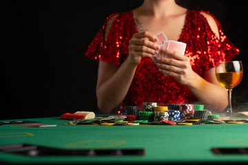 girl in evening dress plays poker in a casino. focus on the card and focus