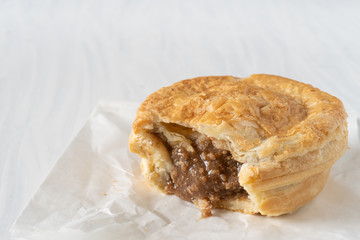 Close Up of  a Take Away Mince Pie on a White Table with Copy Space Horizontal