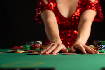 girl in evening dress plays poker in a casino. focus on the card and focus