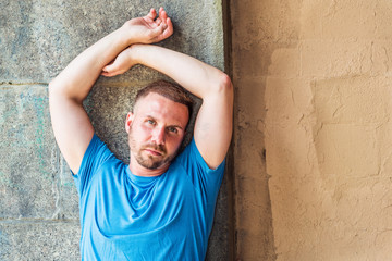 Portrait of Young American Man in New York City. Wearing light blue T shirt, guy with beard...