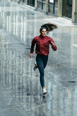 runner girl under the rain along the city