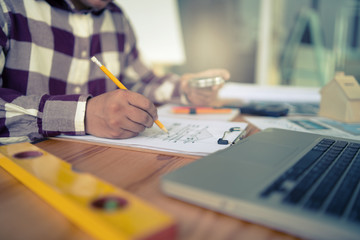 Architect working on blueprint with Circus.engineer inspective in workplace - architectural project, blueprints,ruler,calculator,laptop and divider compass. Construction concept. Engineering tools.