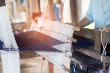 Household Weaving machine Asia weave silks cotton on the manual wood loom in Laos ,Thailand, Cambodia selective focus, traditional Asian silk.for homemade silk or textile fabric cloth production