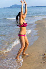 Woman with bikini pink jump exercise on beach