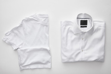 top view of blank t-shirt near plaid shirt on white background