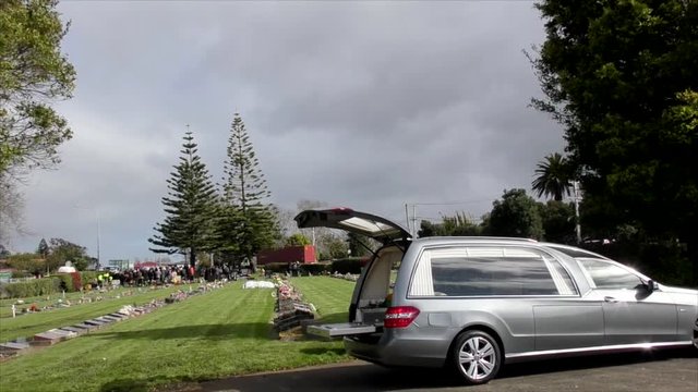 Shot of hearse arriving or leaving a funeral