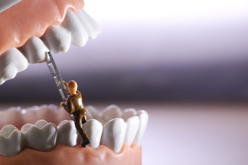 Miniature people or small figure worker cleaning tooth model as medical and healthcare concept....