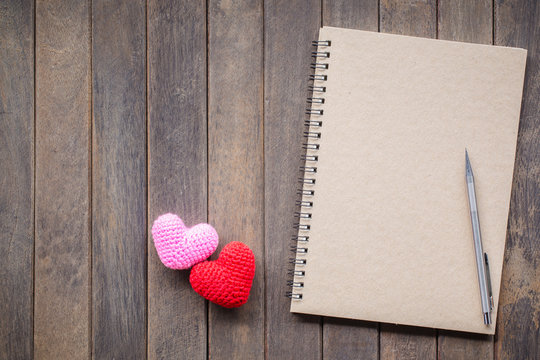 Notebook and Pencil on wood background. Send a message of love.
