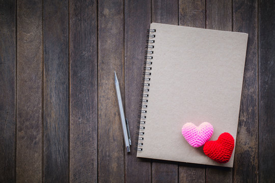 Notebook and Pencil on wood background. Send a message of love.
