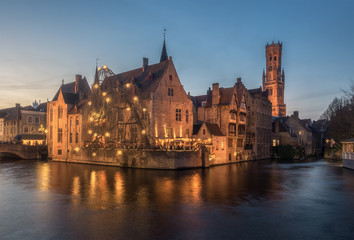 Fototapeta premium Scenic cityscape with a medieval fairytale town and tower Belfort from the quay Rosary, Rozenhoedkaai, at sunset in Bruges, Belgium