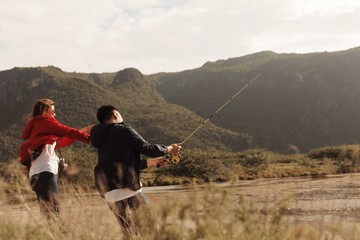 Two Asian  people fishing at lake .