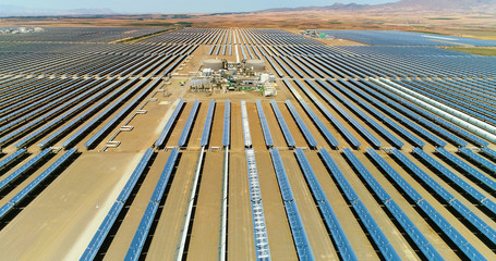 Solar panels in a solar farm in Spain. There is the reflection of the sun in the the panels which...