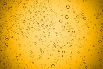 Water drops on yellow glass, Rain droplets on glass background.