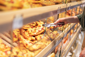 Girl choosing pastry in supermarket. Copy space. Healthy diet concept. Sustainable lifestyle.