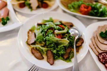 Wedding holiday table, food. Table with silver and glass stemware at restaurant before starting to celebrate. Cheese, meat, salads. Festive decorations. new year, christmas, corporate.