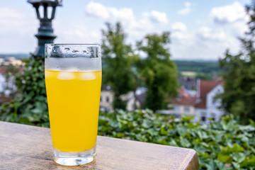 yellow softdrink sitting next to a view in bad bentheim, germany. bright sunny day in July.