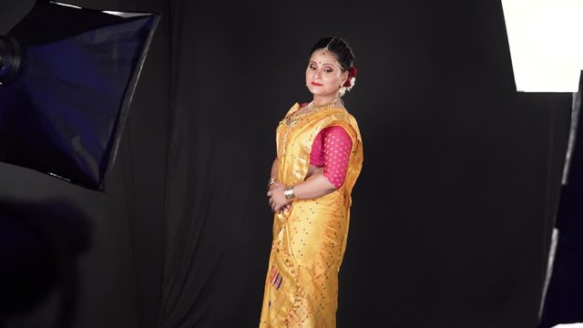 Gorgeous model with magnificent dress posing in studio. Beautiful make up and face decoration
