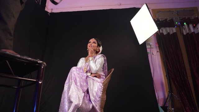 Low angle, studio shot of a gorgeous female model in traditional Indian clothes posing under studio lights