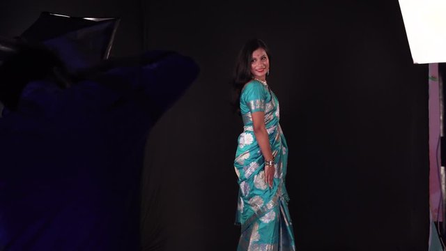 Beutiful Indian photo model with colorful dress being filmed under stuido lights