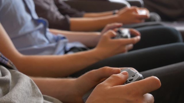 Three friends playing video games on wireless controllers. Friends competition in video games.