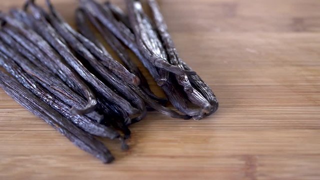 Dried vanilla beans on a wooden background with copy space