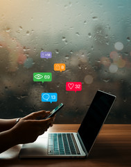 On a rainy day a businesswoman using smartphone for share information online with social media...