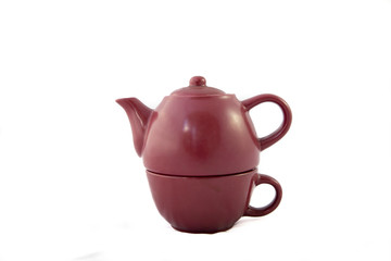 Tetera color granate de ceramica sobre fondo blanco. Vista individual. Recortar. Está dividida en dos partes porque es una tetera individual que tiene el vaso para tomar el té en la parte de abajo. Se