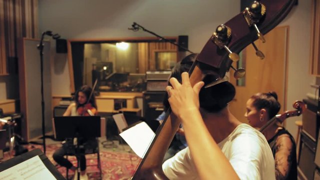 Orchestra Playing in Studio Ending with Scene of Musician with Upright Base