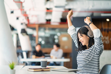 Business women or working lady are stretch oneself or lazily for relaxation on her desk while doing her work in the office.