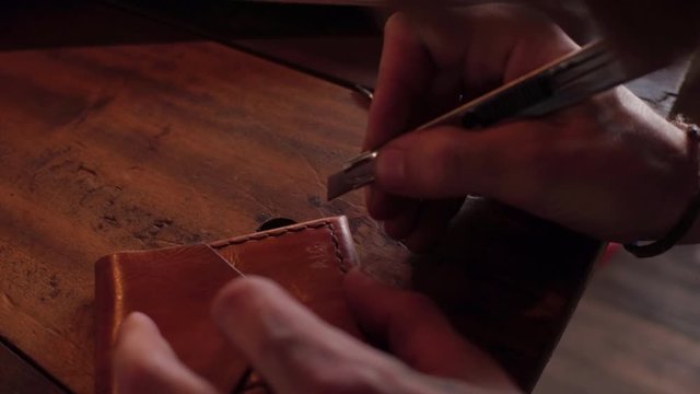 Artisan leather smith creating works of art in his studio